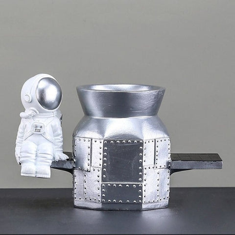 Figurine en résine d'un astronaute assis sur un vaisseau